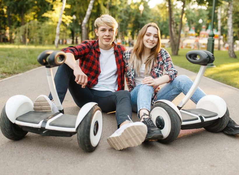 couple-sitting-on-road-with-gyro-board-MSLGQ7C.jpg